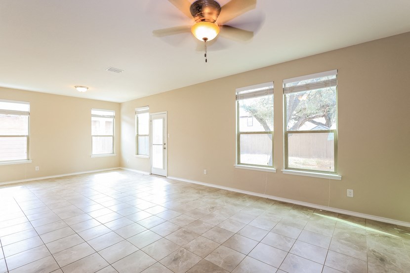 A room with a ceiling fan and tile flooring.