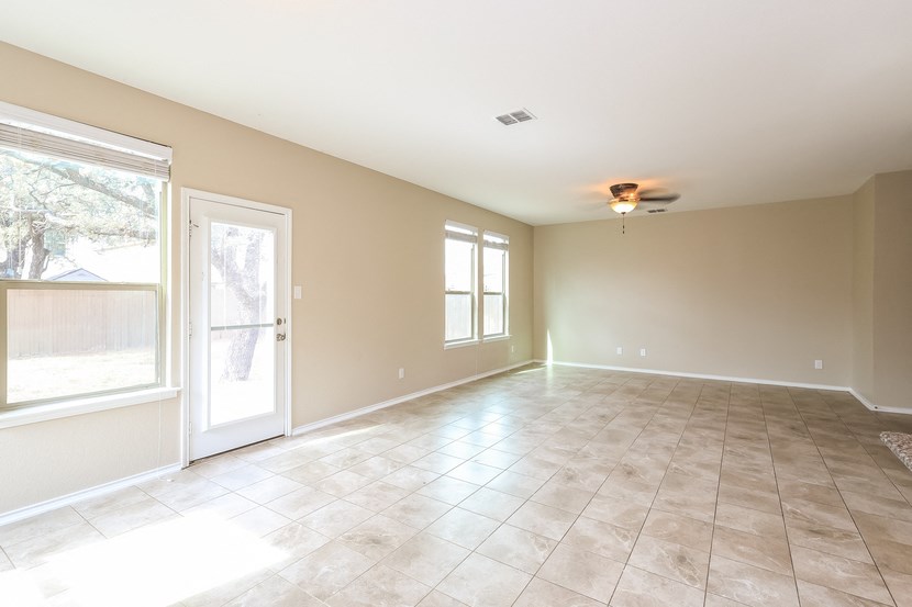 A large empty room with a door and a window.