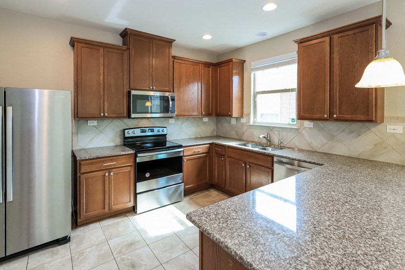 A kitchen with granite countertops and stainless steel appliances.