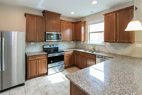 A kitchen with granite countertops and stainless steel appliances.