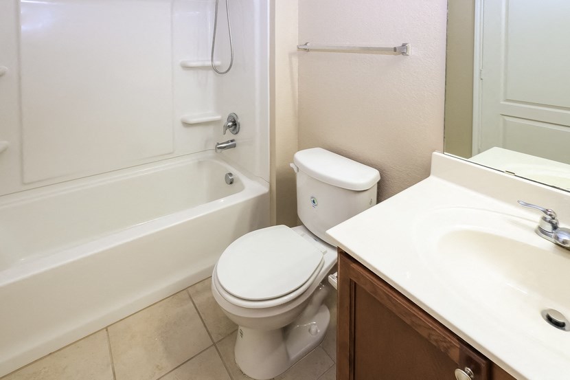 A white toilet sits next to a white sink in a bathroom.