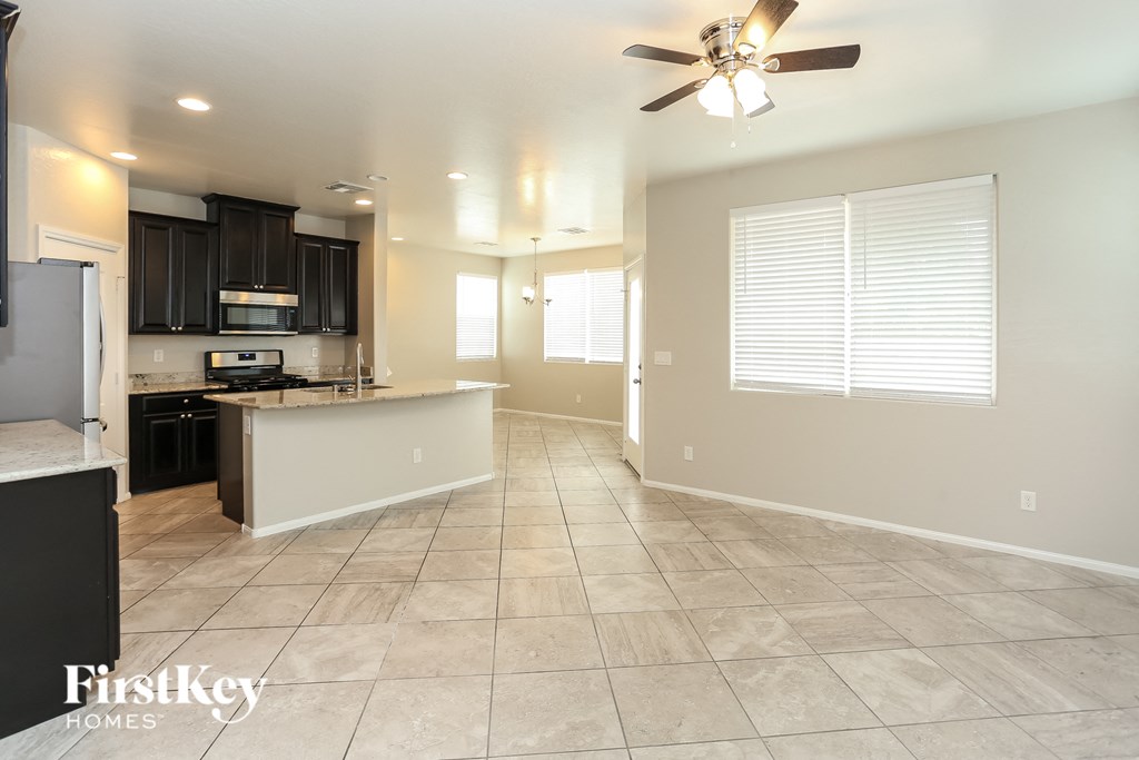 an empty kitchen and living room with a ceiling fan