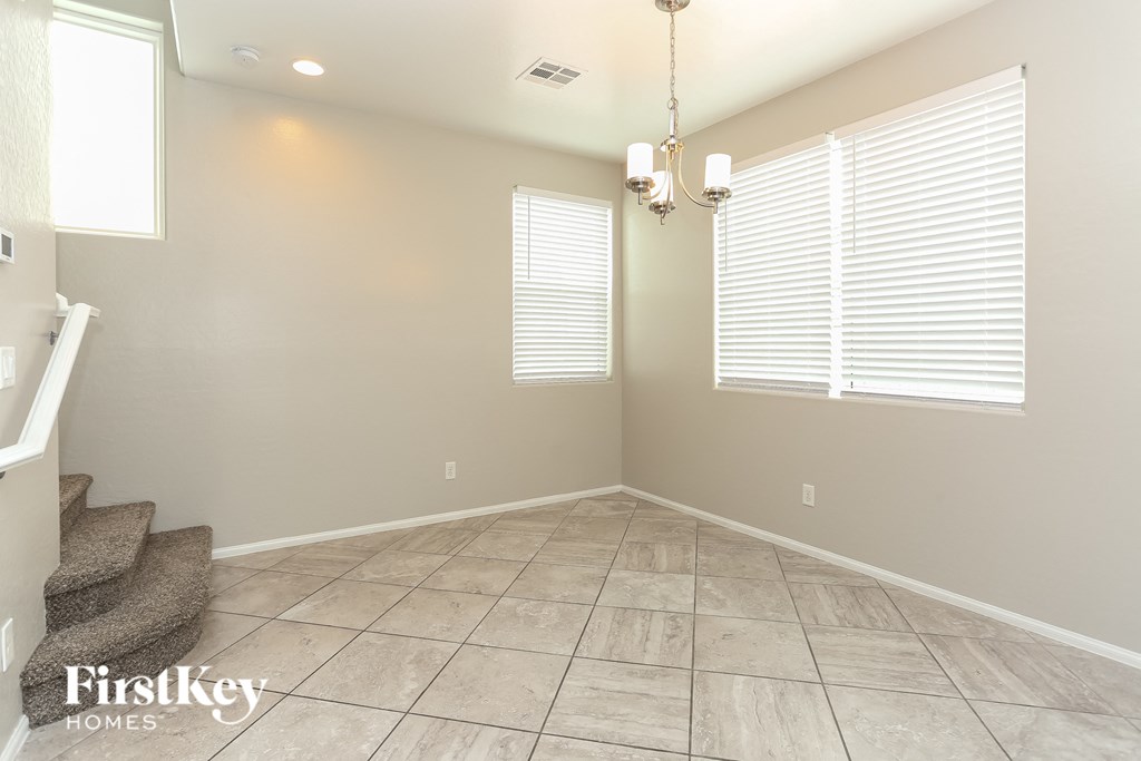 the living room has a large window and a tile floor