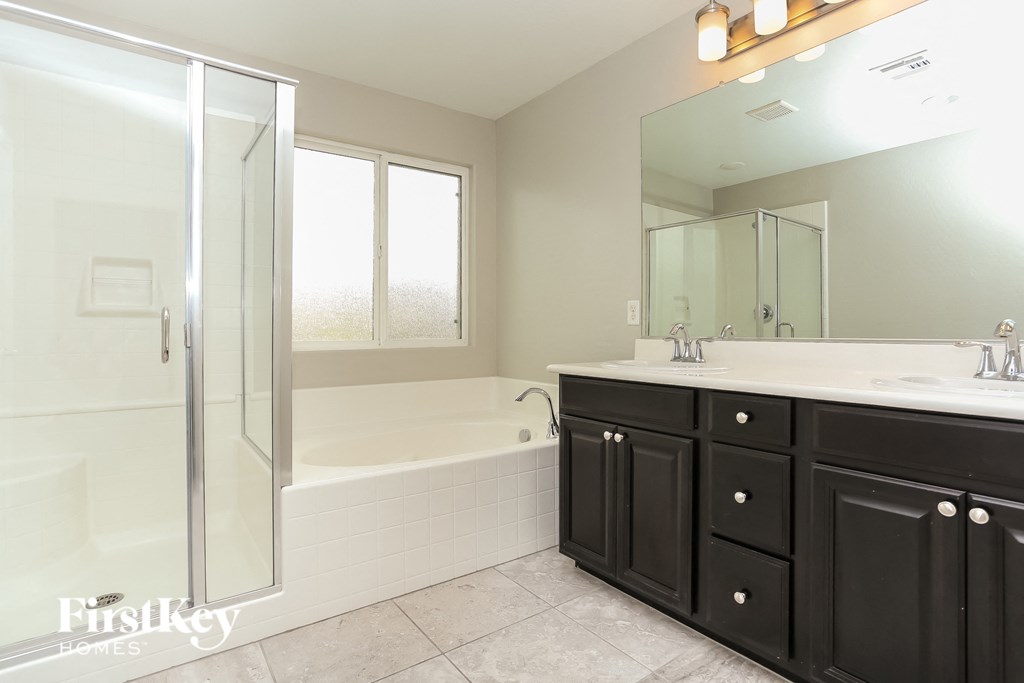 a black and white bathroom with a tub and a sink