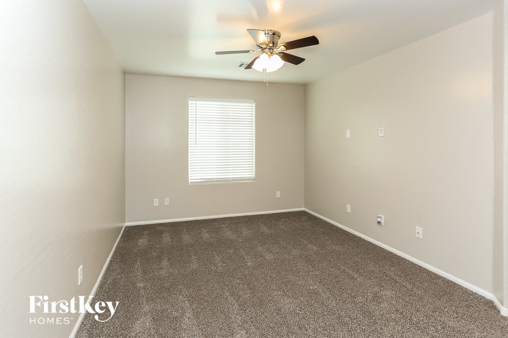 a room with carpet and a ceiling fan