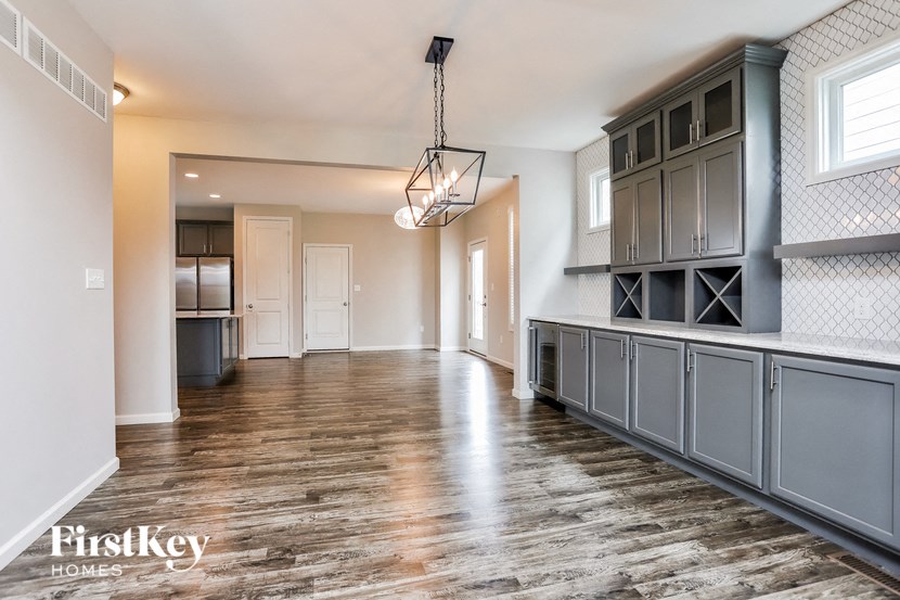 a kitchen with gray cabinets and a large island and a wood floor