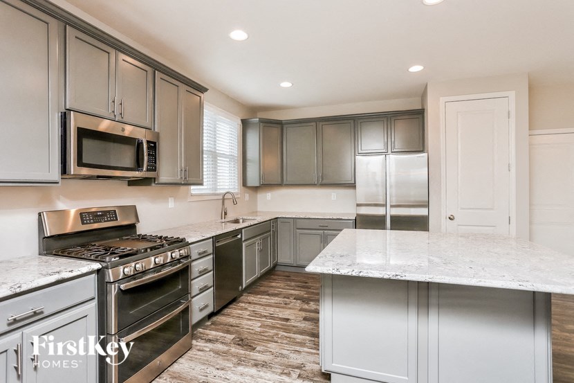 a kitchen with stainless steel appliances and marble counter tops