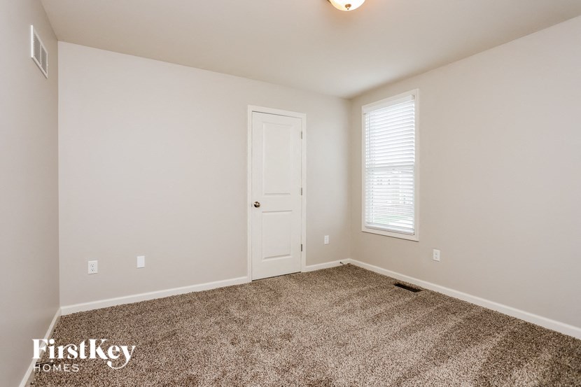 a bedroom with a carpeted floor and a white door