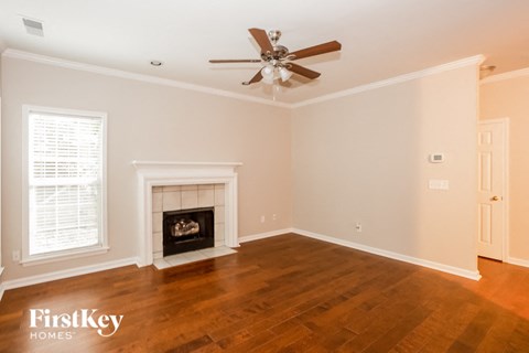 a living room with a fireplace and a ceiling fan
