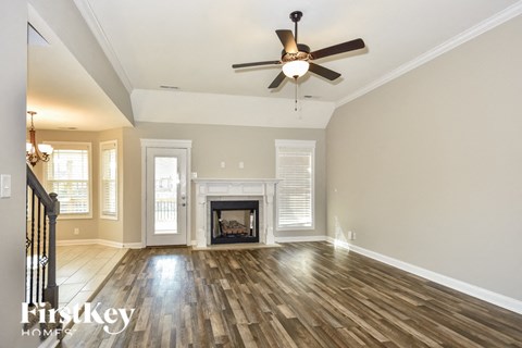 a living room with a fireplace and a ceiling fan