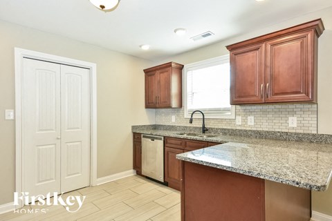 a kitchen with wooden cabinets and granite counter tops and a sink
