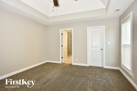 a bedroom with a carpeted floor and a white door