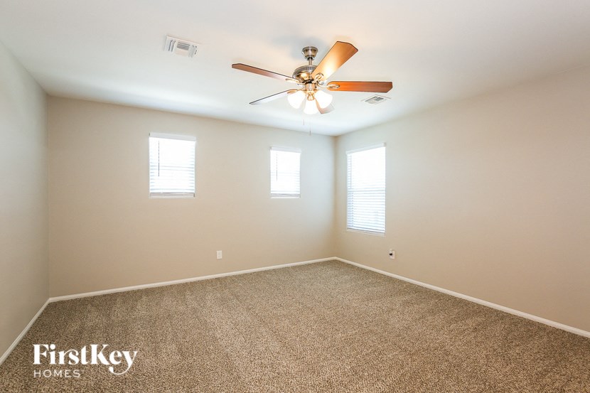 a bedroom with carpet and a ceiling fan