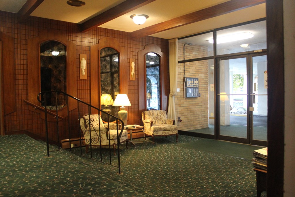 A room with a green carpet and a wooden wall.