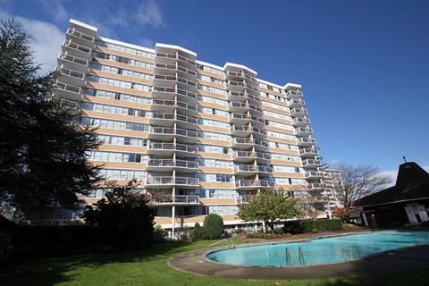 an apartment building with a swimming pool in front of it