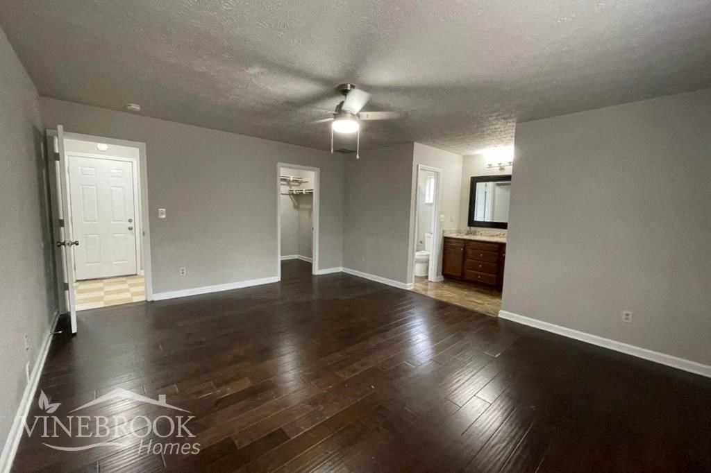 an empty living room with wood floors and a white door