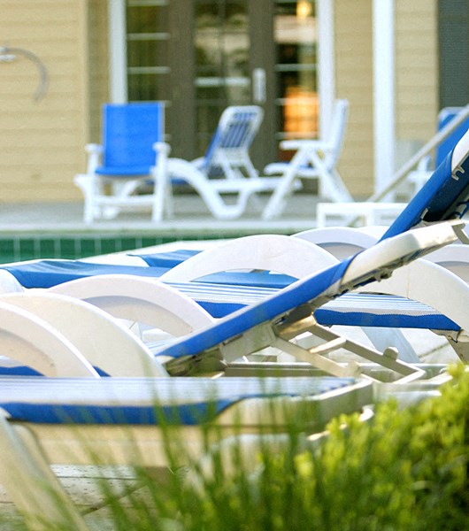 Lounge chairs in a row by pool 