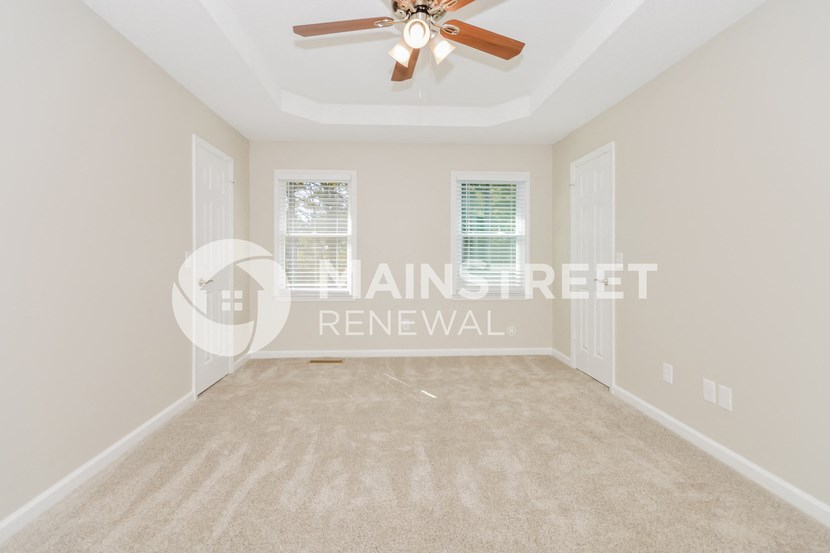 a room with a carpet and a ceiling fan