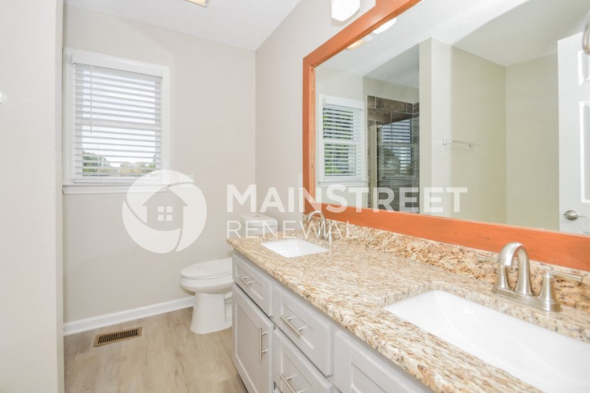 a bathroom with a sink and a toilet and a mirror