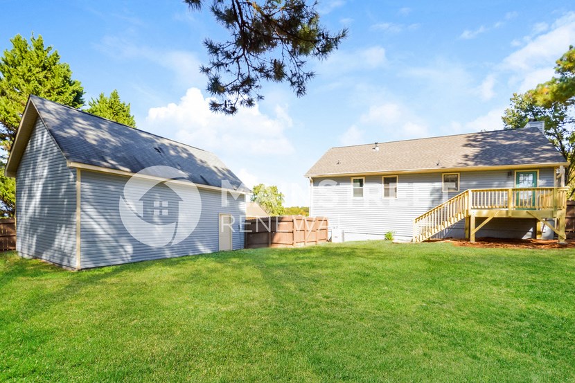 a backyard with a house and a deck