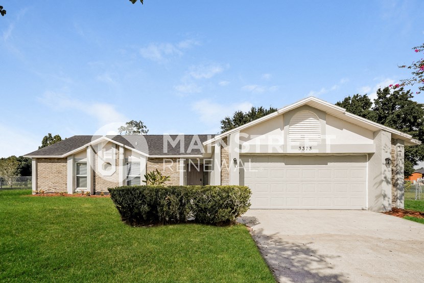 a house with a white garage door and a lawn