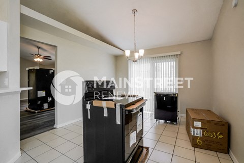 a separate living room and kitchen with a desk and a tv