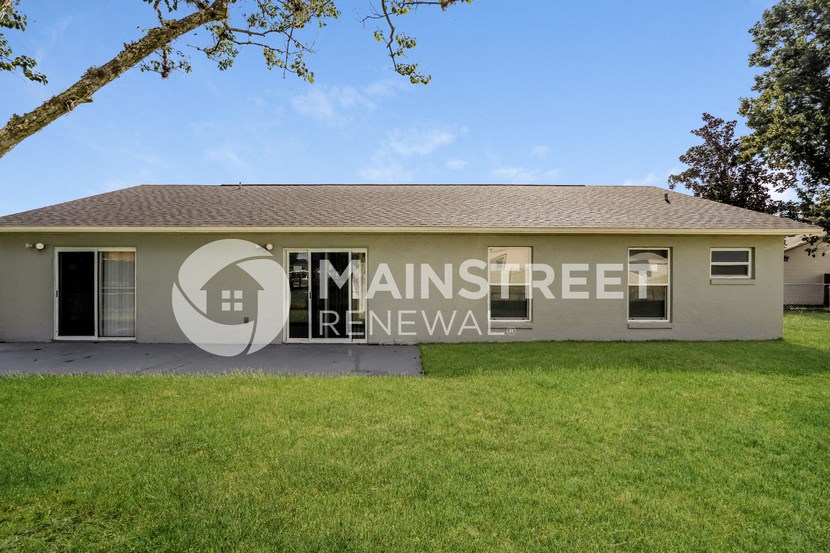a house with a lawn and a sign on the side of it