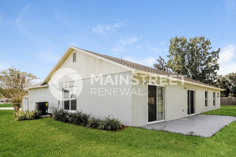 a small white house with a lawn in front