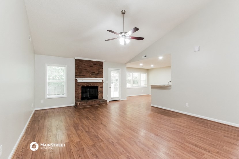 the living room with wood flooring and a fireplace