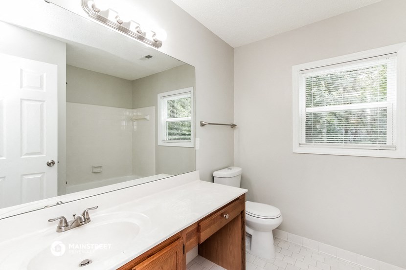a bathroom with a large mirror and a toilet and a sink