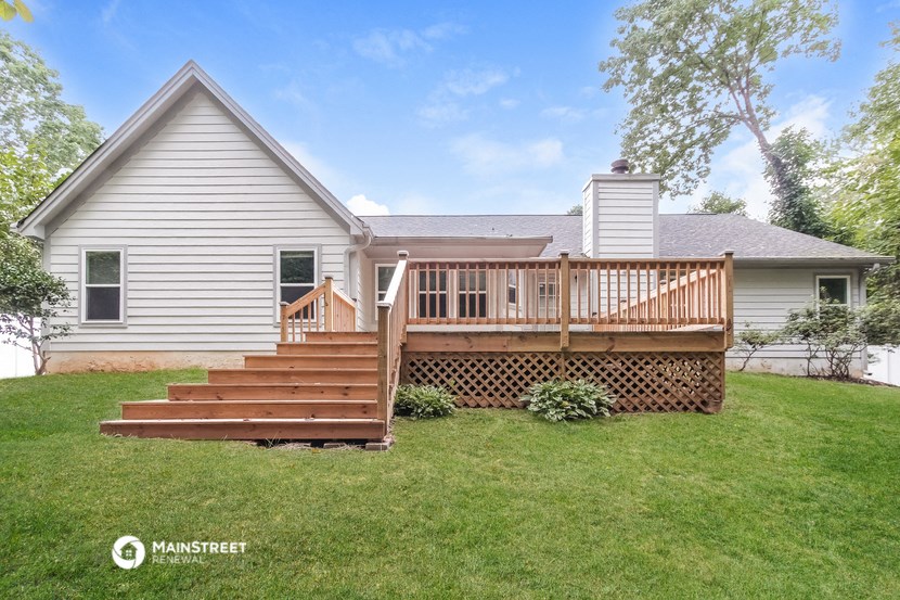 a white house with a porch and a wooden deck