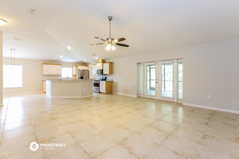 a large living room with a kitchen and a ceiling fan