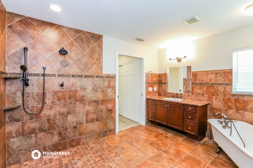 a large bathroom with a tub and a shower and a sink