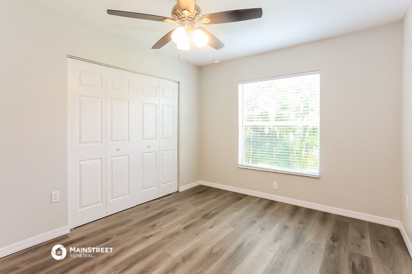 an empty room with a ceiling fan and a window