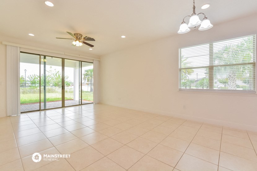 an empty living room with sliding glass doors to a patio