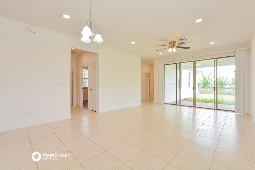 an empty living room with a ceiling fan