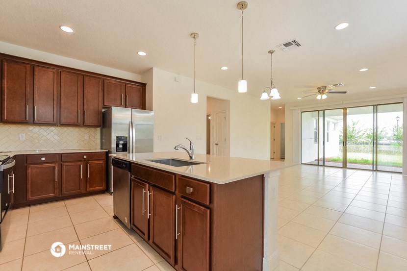 a large kitchen with wooden cabinets and a white counter top