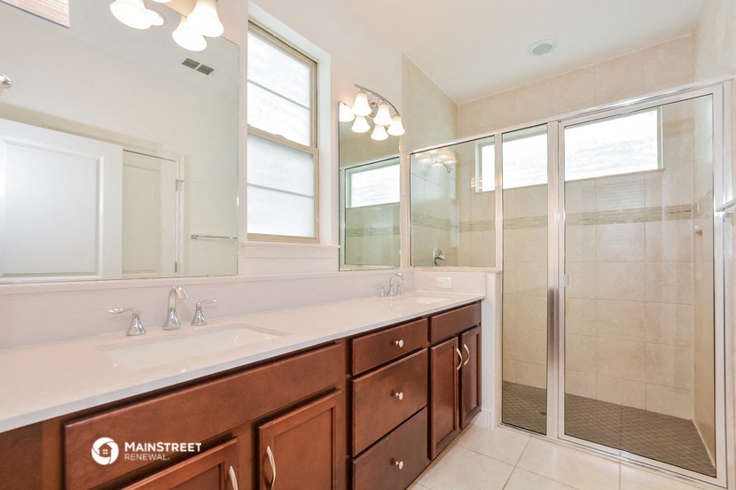 a bathroom with a large mirror and a sink and a shower