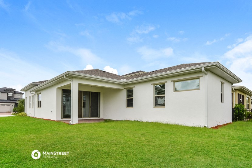 a white house with a green lawn and a blue sky