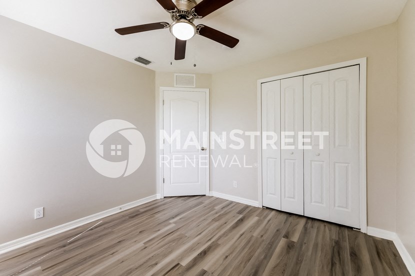 a bedroom with two closets and a ceiling fan