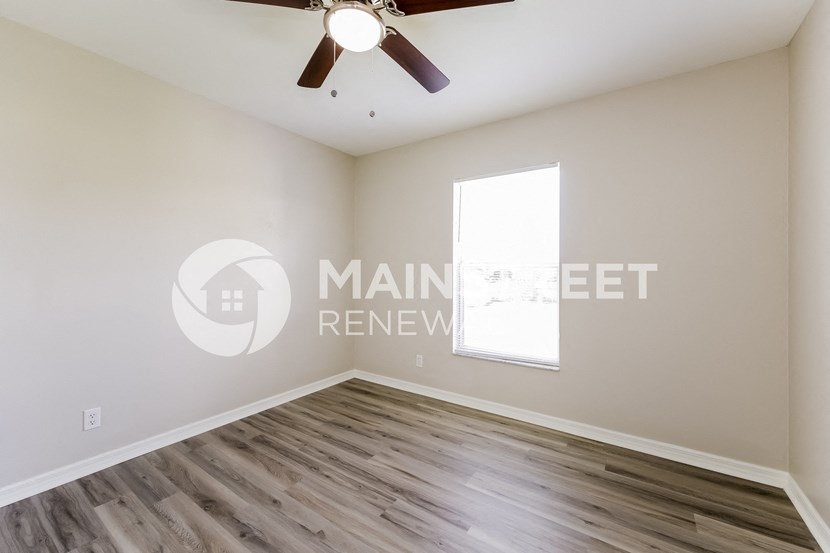 a bedroom with hardwood flooring and a ceiling fan