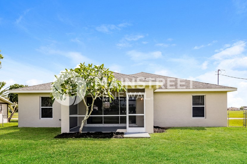 a small white house with a tree in front of it