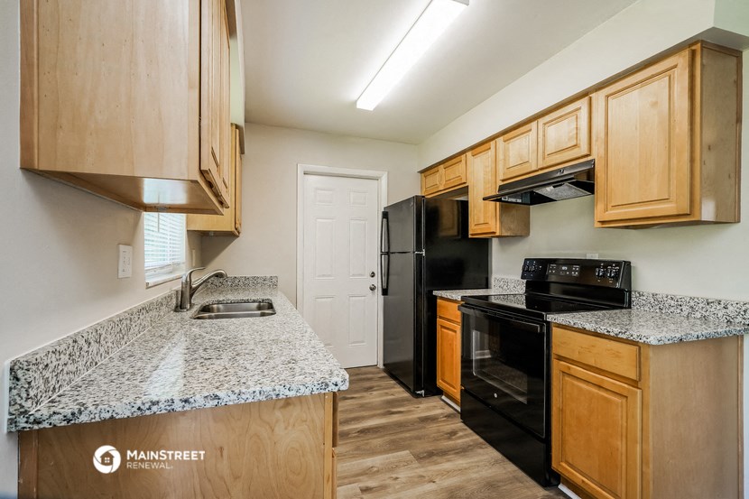 a kitchen with black appliances and granite counter tops