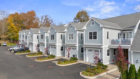a row of town homes with cars parked in front of them