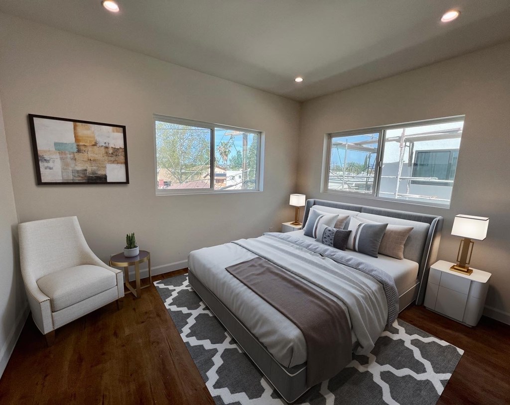 a bedroom with a bed and three windows