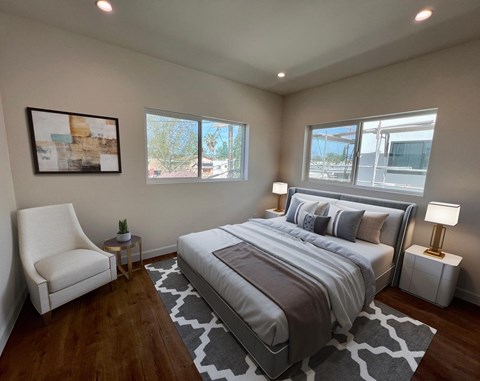 a bedroom with a bed and three windows