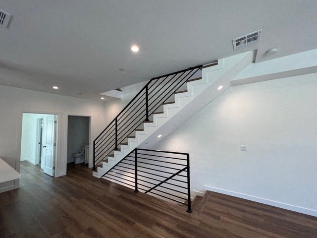 a white staircase in a house with a wooden floor