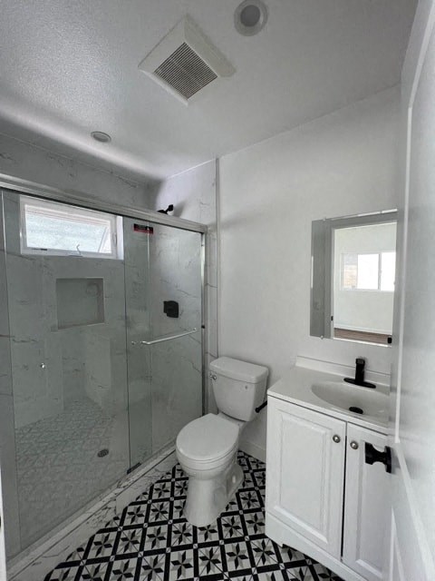 a white bathroom with a toilet and a shower