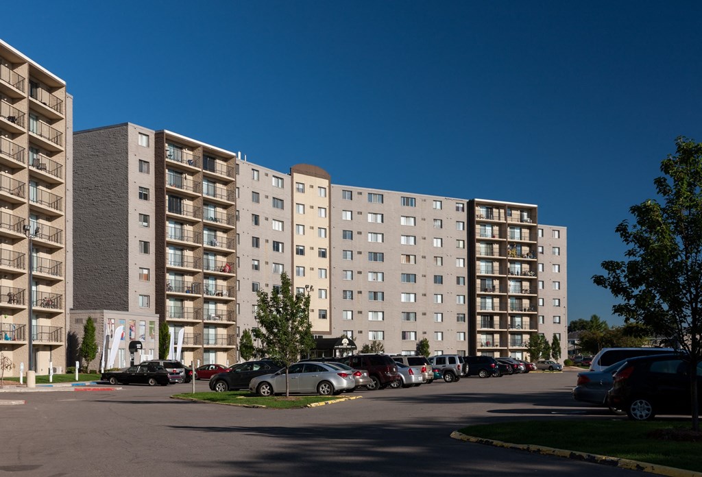 a large apartment building with cars parked in front of it