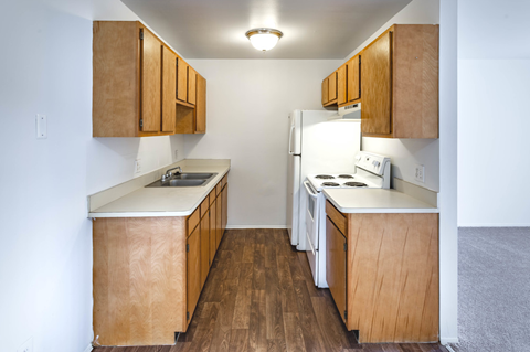 a kitchen with white appliances and wooden cabinets